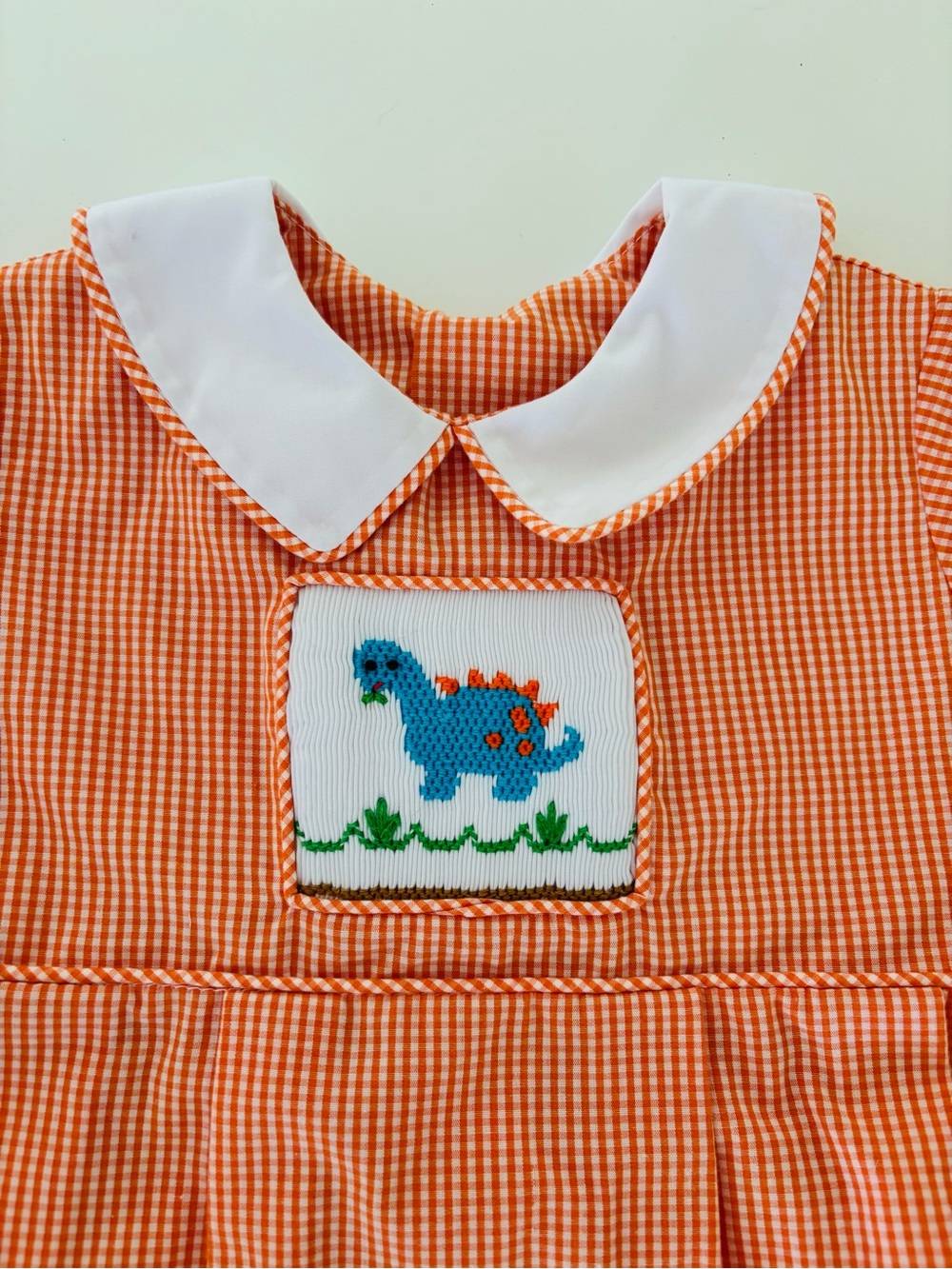 Remember Nguyen - Orange Gingham Kids One-Piece with Blue Dinosaur Smocked Patch
